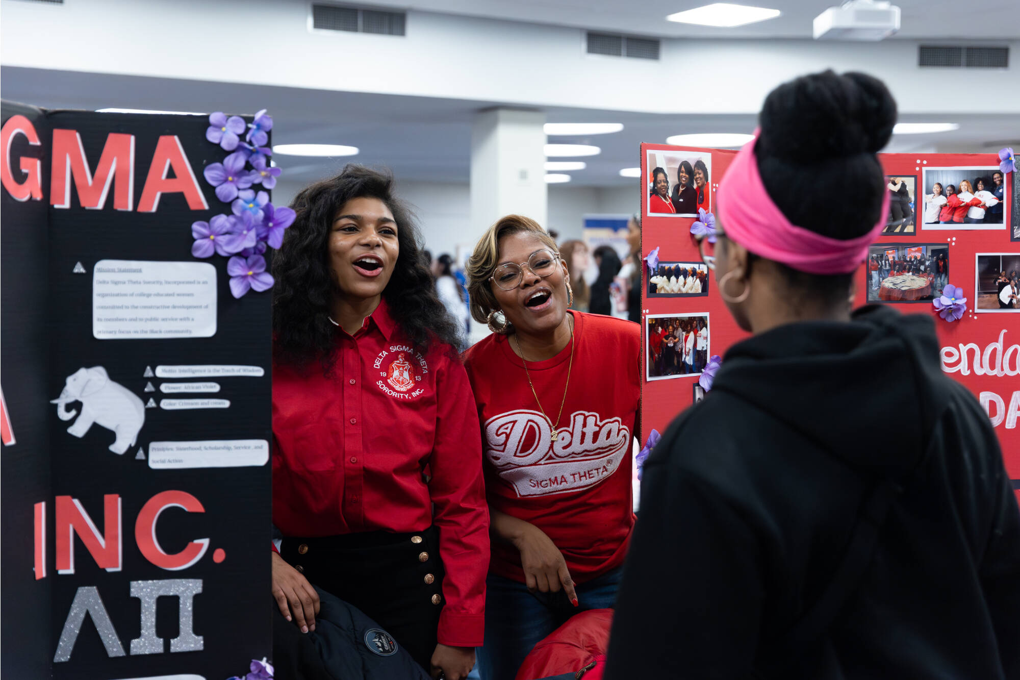 Delta Sigma Gamma smiling at a student